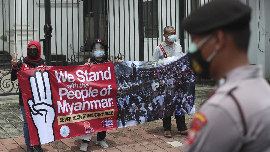 Labor activists destroy a poster of a defaced image of Commander in Chief, Sen. Gen. Min Aung Hlaing during a protest outside the Embassy of Myanmar in Jakarta, Indonesia , Wednesday, March 10, 2021. Dozens of Indonesian labor activists angered over the military coup in Myanmar protested Wednesday outside the Myanmar Embassy in the Indonesian capital. (AP Photo/Achmad Ibrahim)