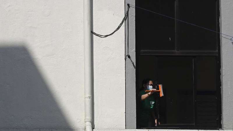 A cat crosses an empty street at a village that was placed under lockdown due to the number of COVID-19 cases among residents in Manila, Philippines on Thursday, March 11, 2021. The Philippine capital placed two villages and two hotels on lockdown Thursday and police have renewed warnings against kissing and other 