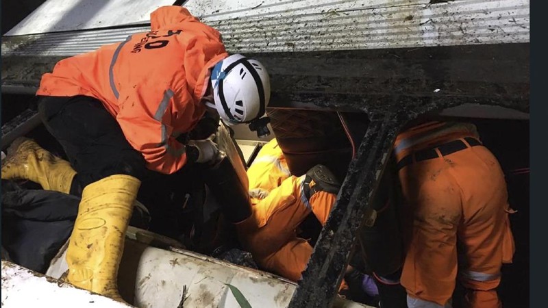 In this photo released by National Search and Rescue Agency (BASARNAS), rescuers search for survivors and victims inside the wreckage of a bus that plunged into a ravine in Sumedang West Java, Indonesia, Thursday, March 11, 2021. The tourist bus plunged into the ravine after its brakes apparently malfunctioned, killing a number of people, police and rescuers said. (BASARNAS via AP)