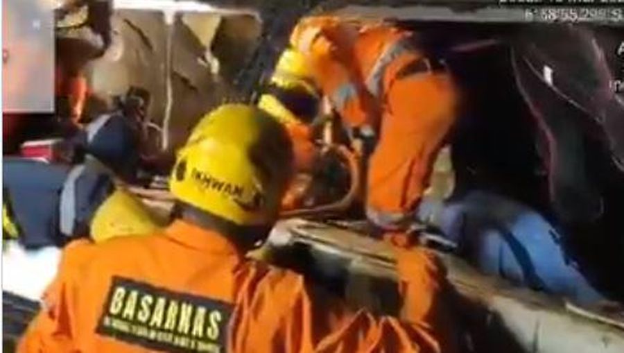 In this photo released by National Search and Rescue Agency (BASARNAS), rescuers search for survivors and victims inside the wreckage of a bus that plunged into a ravine in Sumedang West Java, Indonesia, Thursday, March 11, 2021. The tourist bus plunged into the ravine after its brakes apparently malfunctioned, killing a number of people, police and rescuers said. (BASARNAS via AP)