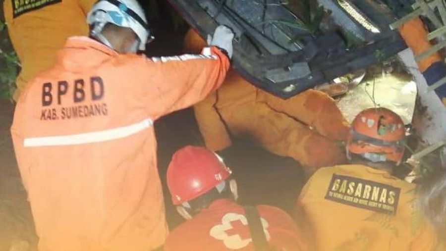 In this photo released by National Search and Rescue Agency (BASARNAS), rescuers search for survivors and victims inside the wreckage of a bus that plunged into a ravine in Sumedang West Java, Indonesia, Thursday, March 11, 2021. The tourist bus plunged into the ravine after its brakes apparently malfunctioned, killing a number of people, police and rescuers said. (BASARNAS via AP)
