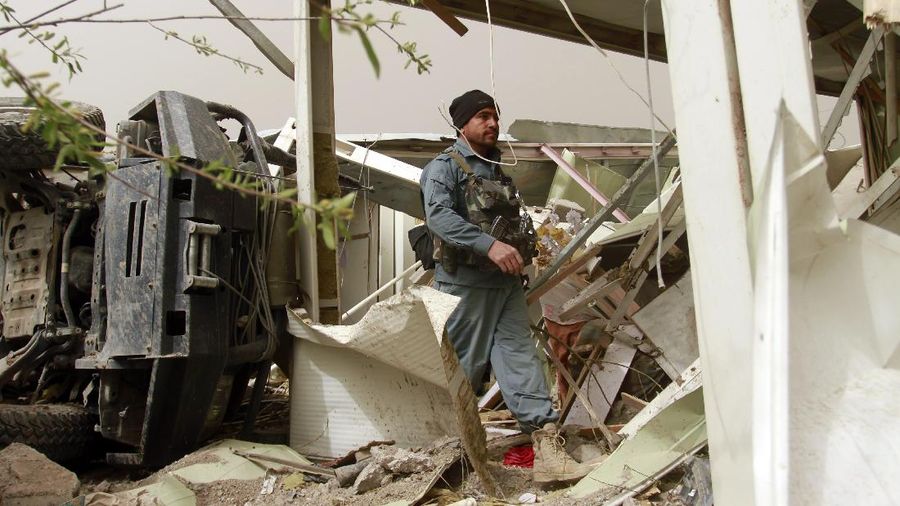Locals inspect the site of a car bomb attack in Herat province, west of Kabul, Afghanistan, Saturday, March 13, 2021. A powerful car bomb killed numerous people and injured dozens more in Afghanistan's western Herat province, officials said Saturday. (AP Photo/Hamed Sarfarazi)