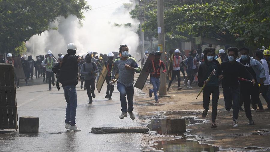 Anti-coup protesters run away after police security forces disperse them with tear gas, which the protesters countered with vapor from fire extinguishers, in Mandalay, Myanmar Saturday, March 13, 2021. Police in Myanmar fired rubber bullets and tear gas at protesters in the country's two largest cities and elsewhere on Friday, as authorities continued their harsh crackdown on opponents of last month's military coup. (AP Photo)