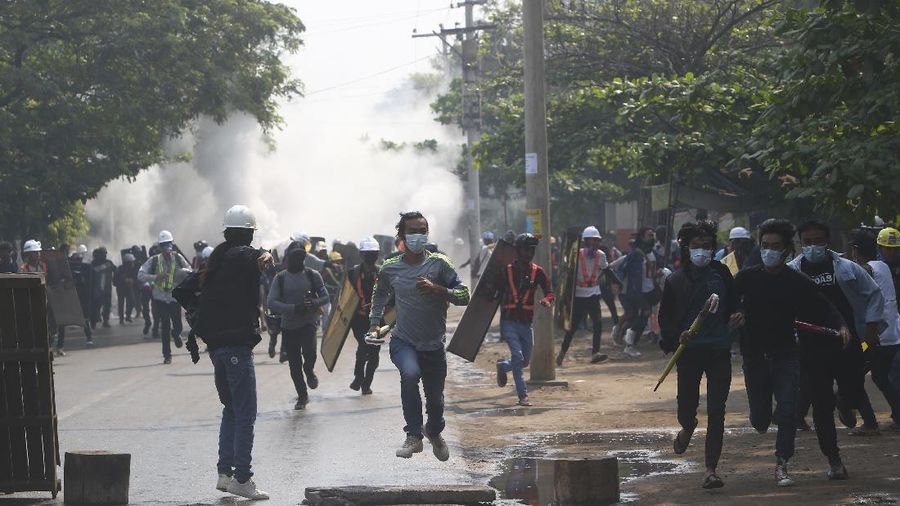 Anti-coup protesters run away after police security forces disperse them with tear gas, which the protesters countered with vapor from fire extinguishers, in Mandalay, Myanmar Saturday, March 13, 2021. Police in Myanmar fired rubber bullets and tear gas at protesters in the country's two largest cities and elsewhere on Friday, as authorities continued their harsh crackdown on opponents of last month's military coup. (AP Photo)