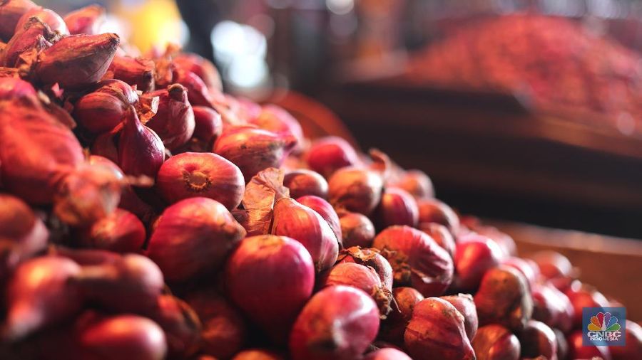 Pekerja menurunkan bawang merah yang baru tiba dari Brebes, Jawa Tengah di Pasar Kramat Jati, Jakarta, Rabu (17/3/2021).  Menurut pedagang setempat harga bawang merah di Jakarta naik dari harga 17 ribu menjadi 28 ribu per kilo gram karena meningkatnya permintaan dan sedikitnya stok bawang merah pada musim penghujan. Pantauan CNBC Indonesia permintaan bawang merah mulai sepi peminat, dari kios Los H bawang merah masih banyak stok. (CNBC Indonesia/ Tri Susilo)