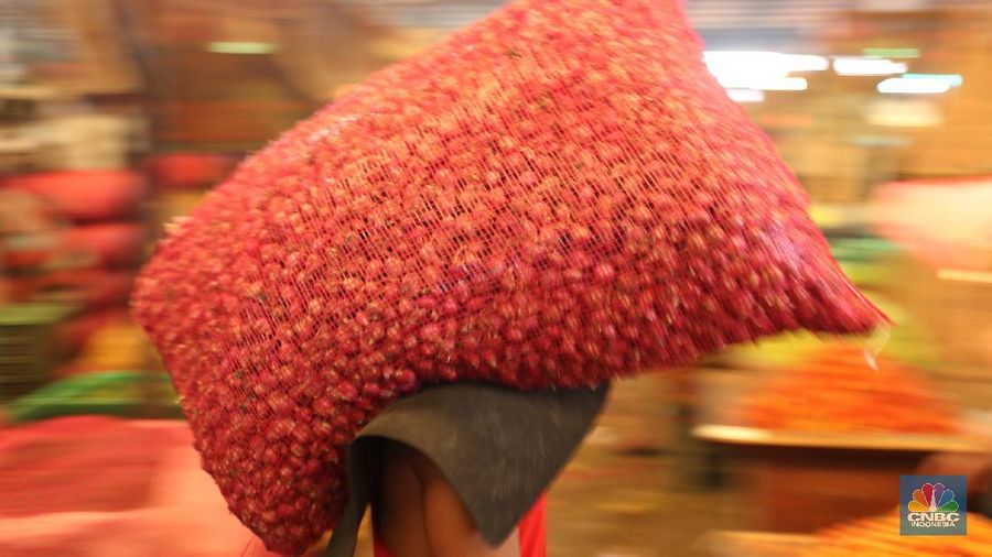 Pekerja menurunkan bawang merah yang baru tiba dari Brebes, Jawa Tengah di Pasar Kramat Jati, Jakarta, Rabu (17/3/2021).  Menurut pedagang setempat harga bawang merah di Jakarta naik dari harga 17 ribu menjadi 28 ribu per kilo gram karena meningkatnya permintaan dan sedikitnya stok bawang merah pada musim penghujan. Pantauan CNBC Indonesia permintaan bawang merah mulai sepi peminat, dari kios Los H bawang merah masih banyak stok. (CNBC Indonesia/ Tri Susilo)