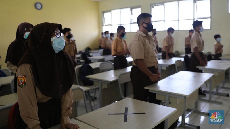 Kegiatan uji coba belajar mengajar tatap muka dengan menerapkan protokol kesehatan di SMPN 1 Bojonggede, Kabupaten Bogor, Jawa Barat, Kamis (18/3/2021). Sebanyak 170 sekolah di Kabupaten Bogor, Jawa Barat menggelar uji coba pembelajaran tatap muka di tengah pandemi virus corona. Tapi tidak semua sekolah yang mengusulkan pembelajaran tatap muka lantas diloloskan. Ratusan sekolah yang menggelar uji coba mulai hari ini terdiri atas 29 SD Negeri, 24 Madrasah Ibtidaiah (MI), 28 SMP, 18 Madrasah Tsanawiah (MTs), tujuh Madrasah Aliyah (MA), 32 SMA, dan 32 SMK. simulasi akan berlangsung sebulan sejak 9 Maret hingga 10 April 2021. Jika pada pelaksanaannya terdapat siswa ataupun guru yang positif Covid-19, maka pembelajaran di sekolah tersebut akan kembali menerapkan sistem daring.  (CNBC Indonesia/ Muhammad Sabki)