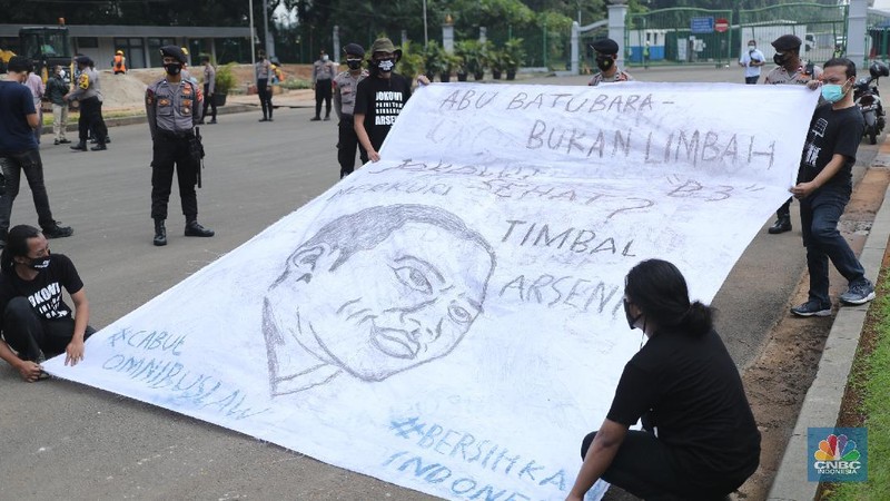Sejumlah aktivis melakukan aksi simbolik menuntut Presiden Joko Widodo untuk mencabut Omnibus Law UU Cipta Kerja dan regulasi turunannya yang menghapus Fly Ash Bottom Ash (FABA) dari daftar limbah B3.di Kawasan Patung Kuda, Jakarta, 18 Maret 2021. (CNBC Indonesia/ Tri Susilo)