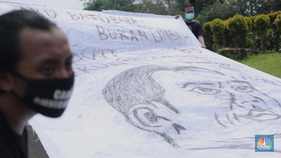 Sejumlah aktivis melakukan aksi simbolik menuntut Presiden Joko Widodo untuk mencabut Omnibus Law UU Cipta Kerja dan regulasi turunannya yang menghapus Fly Ash Bottom Ash (FABA) dari daftar limbah B3.di Kawasan Patung Kuda, Jakarta, 18 Maret 2021. (CNBC Indonesia/ Tri Susilo)