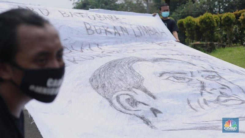 Sejumlah aktivis melakukan aksi simbolik menuntut Presiden Joko Widodo untuk mencabut Omnibus Law UU Cipta Kerja dan regulasi turunannya yang menghapus Fly Ash Bottom Ash (FABA) dari daftar limbah B3.di Kawasan Patung Kuda, Jakarta, 18 Maret 2021. (CNBC Indonesia/ Tri Susilo)