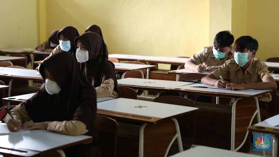 Kegiatan uji coba belajar mengajar tatap muka dengan menerapkan protokol kesehatan di SMPN 1 Bojonggede, Kabupaten Bogor, Jawa Barat, Kamis (18/3/2021). Sebanyak 170 sekolah di Kabupaten Bogor, Jawa Barat menggelar uji coba pembelajaran tatap muka di tengah pandemi virus corona. Tapi tidak semua sekolah yang mengusulkan pembelajaran tatap muka lantas diloloskan. Ratusan sekolah yang menggelar uji coba mulai hari ini terdiri atas 29 SD Negeri, 24 Madrasah Ibtidaiah (MI), 28 SMP, 18 Madrasah Tsanawiah (MTs), tujuh Madrasah Aliyah (MA), 32 SMA, dan 32 SMK. simulasi akan berlangsung sebulan sejak 9 Maret hingga 10 April 2021. Jika pada pelaksanaannya terdapat siswa ataupun guru yang positif Covid-19, maka pembelajaran di sekolah tersebut akan kembali menerapkan sistem daring.  (CNBC Indonesia/ Muhammad Sabki)