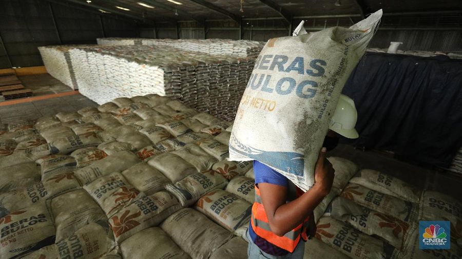Pekerja merapikan beras Bulog di Gudang Bulog, Divisi Regional DKI Jakarta dan Banten  yang berada di kawasan Kelapa Gading, Jakarta (19/3/2021) . Pemerintah berencana Impor beras 1 juta ton. Dirut Perum Bulog Budi Waseso pun buka - bukaan soal kondisi ratusan ribu ton beras yang belum terpakai.   (CNBC Indonesia/ Tri Susuilo)