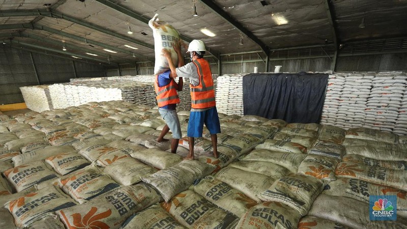Pekerja merapikan beras Bulog di Gudang Bulog, Divisi Regional DKI Jakarta dan Banten  yang berada di kawasan Kelapa Gading, Jakarta (19/3/2021) . Pemerintah berencana Impor beras 1 juta ton. Dirut Perum Bulog Budi Waseso pun buka - bukaan soal kondisi ratusan ribu ton beras yang belum terpakai.   (CNBC Indonesia/ Tri Susuilo)