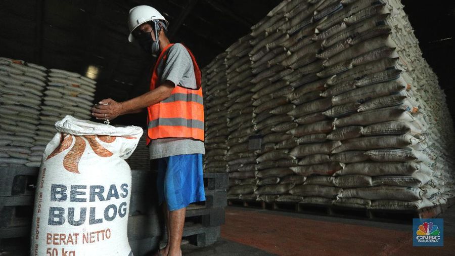 Pekerja merapikan beras Bulog di Gudang Bulog, Divisi Regional DKI Jakarta dan Banten  yang berada di kawasan Kelapa Gading, Jakarta (19/3/2021) . Pemerintah berencana Impor beras 1 juta ton. Dirut Perum Bulog Budi Waseso pun buka - bukaan soal kondisi ratusan ribu ton beras yang belum terpakai.   (CNBC Indonesia/ Tri Susuilo)