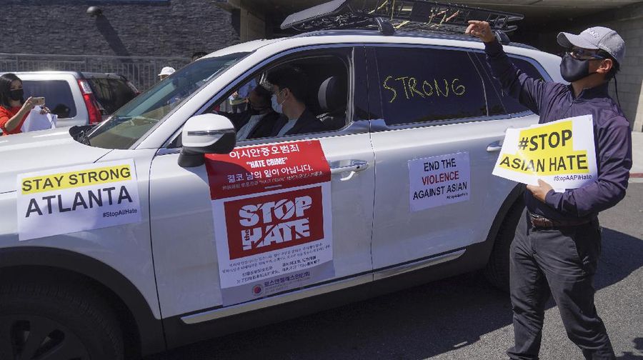 Members of the Korean American Federation of Los Angeles drive with signs reading: 