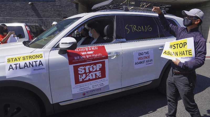 Members of the Korean American Federation of Los Angeles drive with signs reading: 