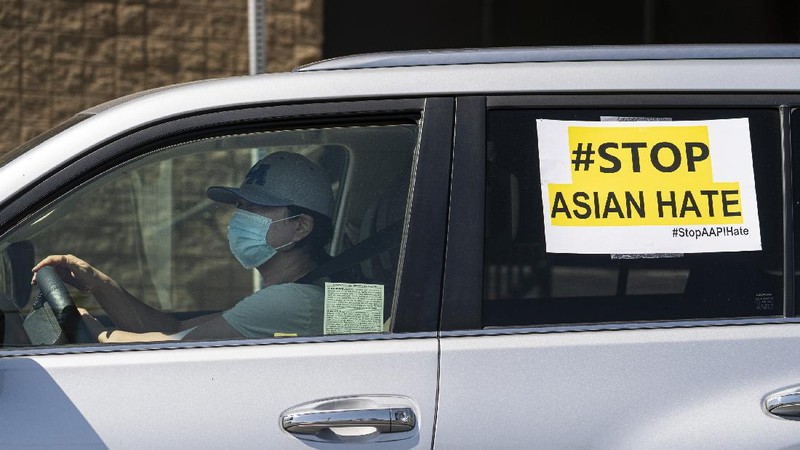 Members of the Korean American Federation of Los Angeles drive with signs reading: 