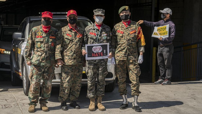 Members of the Korean American Federation of Los Angeles drive with signs reading: 