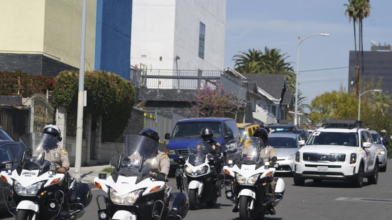 Members of the Korean American Federation of Los Angeles drive with signs reading: 