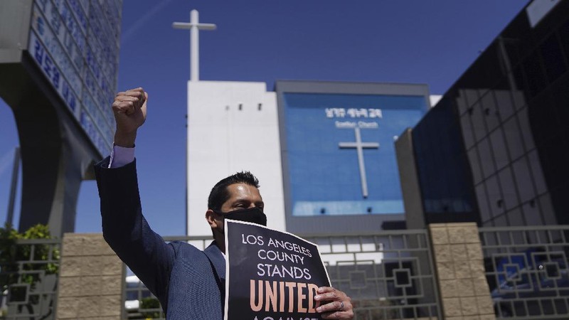 Members of the Korean American Federation of Los Angeles drive with signs reading: 
