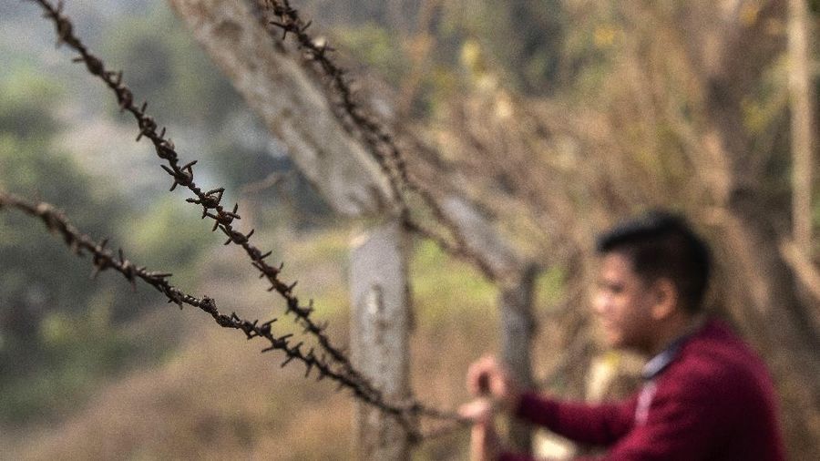 An Indian looks at the Myanmar side across Tiau river which bifurcated India and Myanmar, in Champhai village in Mizoram, India, Saturday, March 20, 2021. Several Myanmar police officers who fled to India after defying army orders to shoot opponents of last month’s coup are urging Prime Minister Narendra Modi’s government to not repatriate them and provide them political asylum on humanitarian grounds.(AP Photo/Anupam Nath)