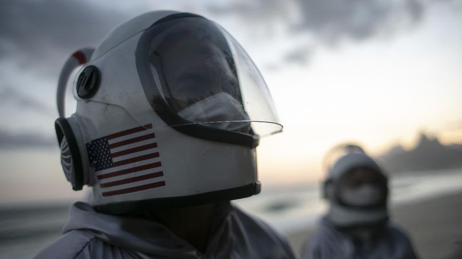 Accountant Tercio Galdino and wife Alicea, dressed in their astronaut costumes, watch as bystanders make photos of them on Ipanema beach in Rio de Janeiro, Brazil, Saturday, March 20, 2021. The Galdinos have come up with a unique way for protecting themselves and drawing awareness around COVID-19 protective measures – by dressing as astronauts. The pair first began to traverse the iconic beaches fully suited in mid 2020 at the height of the first wave of the pandemic in Brazil, now as cases surge once again they are taking their ‘astronaut walks’ back to the promenades. (AP Photo/Bruna Prado)