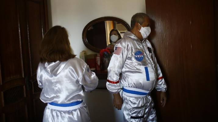 Accountant Tercio Galdino and wife Alicea, dressed in their astronaut costumes, watch as bystanders make photos of them on Ipanema beach in Rio de Janeiro, Brazil, Saturday, March 20, 2021. The Galdinos have come up with a unique way for protecting themselves and drawing awareness around COVID-19 protective measures – by dressing as astronauts. The pair first began to traverse the iconic beaches fully suited in mid 2020 at the height of the first wave of the pandemic in Brazil, now as cases surge once again they are taking their ‘astronaut walks’ back to the promenades. (AP Photo/Bruna Prado)