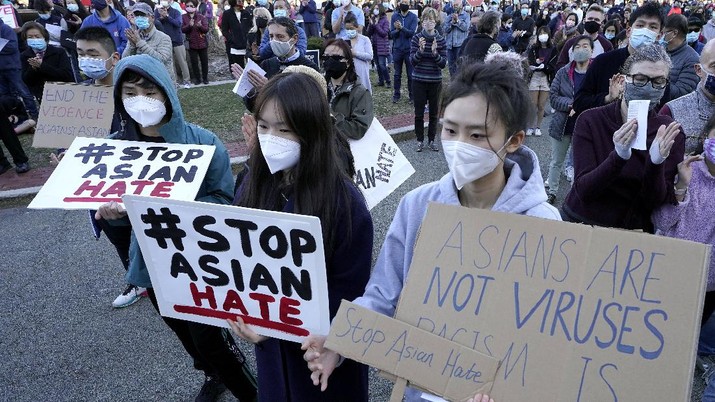 Demo Asian Hate Protesters Dana Liu, center front, and Kexin Huang, right, both of Newton, Mass., display placards during a rally held to support Stop Asian Hate, Sunday, March 21, 2021, in Newton. A gunman has been charged with killing eight people at three Atlanta-area massage parlors in an attack Tuesday, March 16. Seven of the eight people killed in the attacks were women, six were of Asian descent. (AP Photo/Steven Senne)