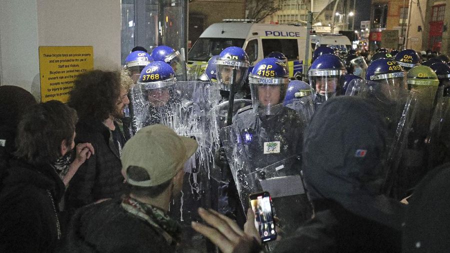 Protesters set fire to a vandalized police van outside Bridewell Police Station, in Bristol, England, Sunday March 21, 2021, as people took part in a protest demonstrating against the Police and Crime Bill. (Andrew Matthews/PA via AP)