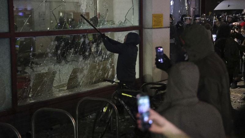 Protesters set fire to a vandalized police van outside Bridewell Police Station, in Bristol, England, Sunday March 21, 2021, as people took part in a protest demonstrating against the Police and Crime Bill. (Andrew Matthews/PA via AP)