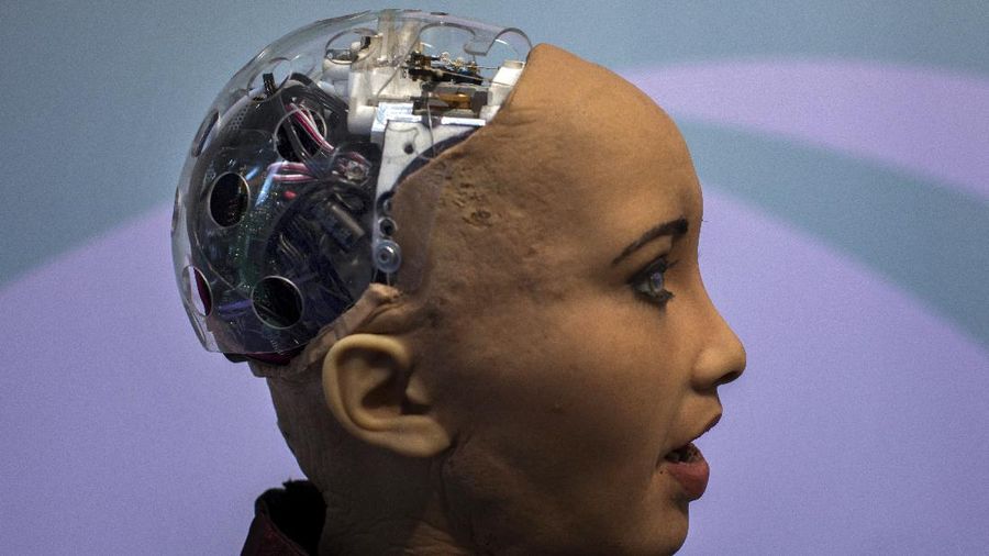 Hanson Robotics' flagship robot Sophia, a lifelike robot powered by artificial intelligence, speaks with visitors, at the Mobile World Congress wireless show, in Barcelona, Spain, Tuesday, Feb. 26, 2019. The annual Mobile World Congress (MWC) runs from 25-28 February in Barcelona, where companies from all over the world gather to share new products. (AP Photo/Emilio Morenatti)