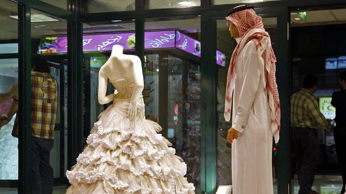 FILE - In this Sunday, Aug. 3, 2008 file photo, a Saudi man stands in front of a wedding dress at a shop in Riyadh, Saudi Arabia. In the Middle East, Saudi Arabia and Yemen are the only Arab countries that do not have laws that set a minimum age for marriage. According to a December 2011 Human Rights Watch report, approximately 14 percent of girls in the Arab worlds poorest nation of Yemen were married before the age 15, and 52 percent were married before 18 years old. (AP Photo, File)