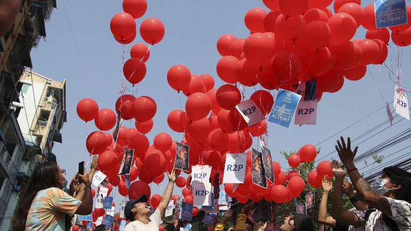 Anti-coup protesters hold red balloon, calling for foreign intervention to aid them in downtown Yangon, Myanmar, Monday, March 22, 2021. Protests against the coup continued in cities and town across the country, including Mandalay and Yangon. (AP Photo)