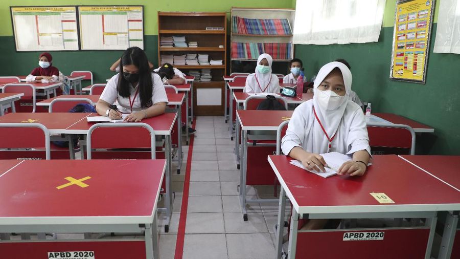 A teacher wears a face mask as a precaution against the coronavirus during a class in Bekasi on the outskirts of Jakarta, Indonesia. Tuesday, March 23, 2021. (AP Photo/Achmad Ibrahim)