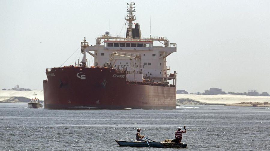 FILE - In this Aug. 12, 2014, file photo, Egyptian fishermen fish in front of a Maltese ship crossing the Suez Canal in Ismailia, Egypt. A massive cargo ship has turned sideways in Egypt's Suez Canal, blocking traffic in a crucial East-West waterway for global shipping, according to satellite data accessed Wednesday, March 24, 2021. (AP Photo/Amr Nabil, File)