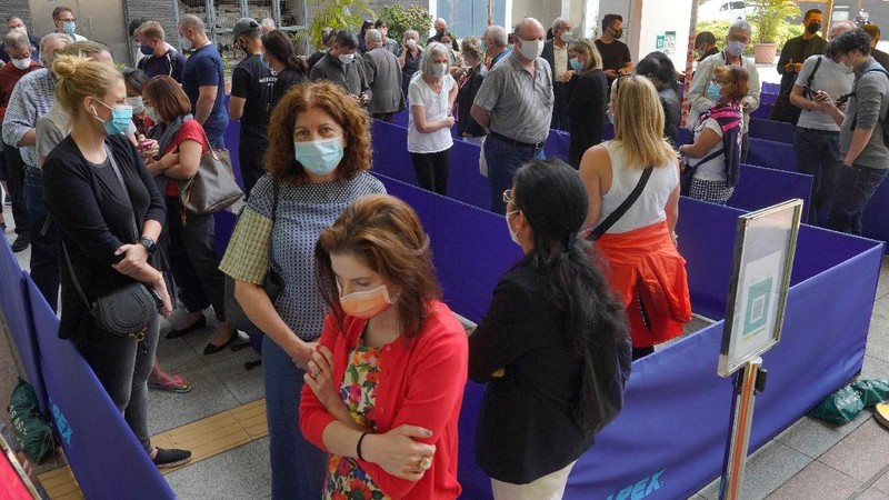People queue up outside a vaccination center for BioNTech in Hong Kong Wednesday, March 24, 2021. Hong Kong suspended vaccinations using Pfizer shots - known as BioNTech shots in the city - on Wednesday after they were informed by its distributor Fosun that one batch had defective bottle lids. (AP Photo/Vincent Yu)