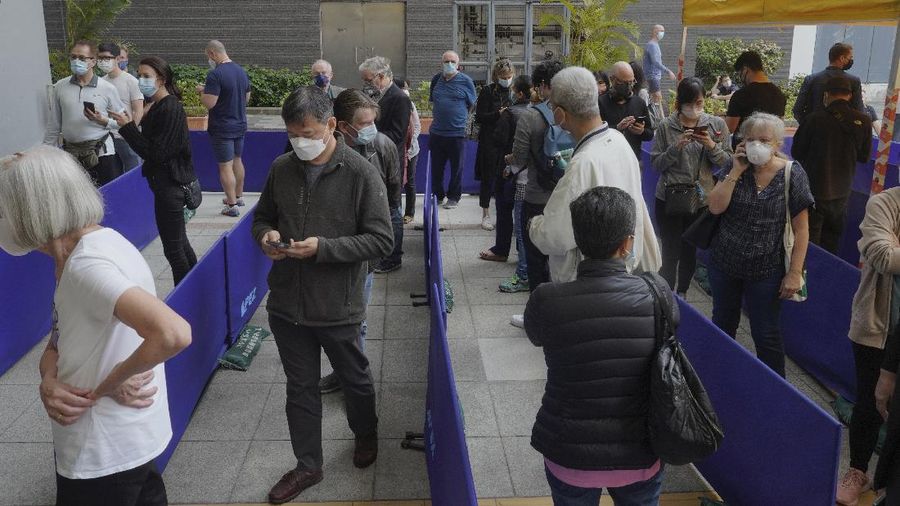 People queue up outside a vaccination center for BioNTech in Hong Kong Wednesday, March 24, 2021. Hong Kong suspended vaccinations using Pfizer shots - known as BioNTech shots in the city - on Wednesday after they were informed by its distributor Fosun that one batch had defective bottle lids. (AP Photo/Vincent Yu)
