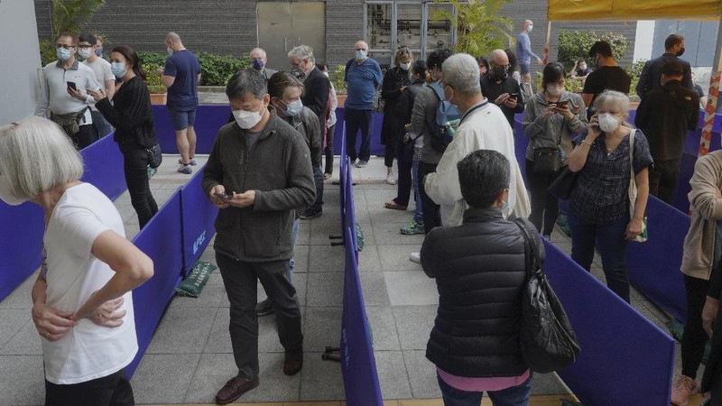People queue up outside a vaccination center for BioNTech in Hong Kong Wednesday, March 24, 2021. Hong Kong suspended vaccinations using Pfizer shots - known as BioNTech shots in the city - on Wednesday after they were informed by its distributor Fosun that one batch had defective bottle lids. (AP Photo/Vincent Yu)