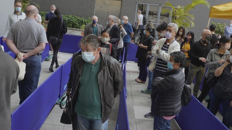 People queue up outside a vaccination center for BioNTech in Hong Kong Wednesday, March 24, 2021. Hong Kong suspended vaccinations using Pfizer shots - known as BioNTech shots in the city - on Wednesday after they were informed by its distributor Fosun that one batch had defective bottle lids. (AP Photo/Vincent Yu)