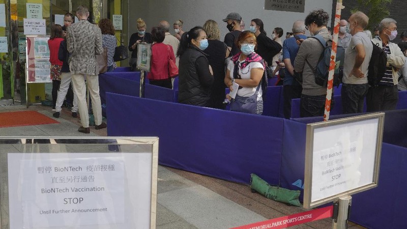 People queue up outside a vaccination center for BioNTech in Hong Kong Wednesday, March 24, 2021. Hong Kong suspended vaccinations using Pfizer shots - known as BioNTech shots in the city - on Wednesday after they were informed by its distributor Fosun that one batch had defective bottle lids. (AP Photo/Vincent Yu)
