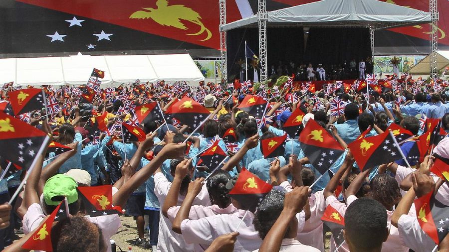 Thousands of children wave flags while performing for Britain's Prince Charles and his wife Camilla, Duchess of Cornwall, during a cultural display in Port Moresby , Papua New Guinea, Sunday, Nov. 4, 2012. The royal couple are in Papua New Guinea for three days, followed by a visit to Australia and New Zealand.  (AP Photo/Rob Griffith)