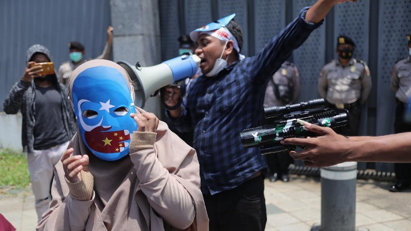 Sejumlah massa menggelar aksi protes di depan Kedubes Tiongkok, Mega Kuningan, Jakarta, Kamis (25/3/2021). Massa aksi mengancam tindakan diskriminatif yang dialami etnis Muslim Uighur di Xianjiang, China. (CNBC Indonesia/Tri Susilo)
