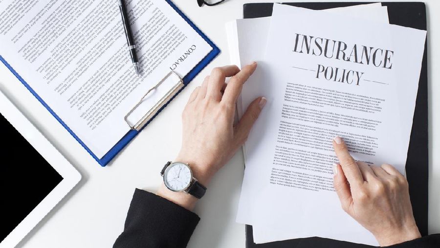 Business woman showing insurance document over white desk at office