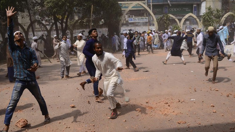 A group of protestors pelt stones on another after Friday prayers at Baitul Mokarram mosque in Dhaka, Bangladesh, Friday, March 26, 2021. Witnesses said violent clashes broke out after one faction of protesters began waving their shoes as a sign of disrespect to Indian Prime Minister Narendra Modi, and another group tried to stop them. Local media said the protesters who tried to stop the shoe-waving are aligned with the ruling Awami League party. The party criticized the other protest faction for attempting to create chaos in the country during Modi’s visit. (AP Photo/Mahmud Hossain Opu)