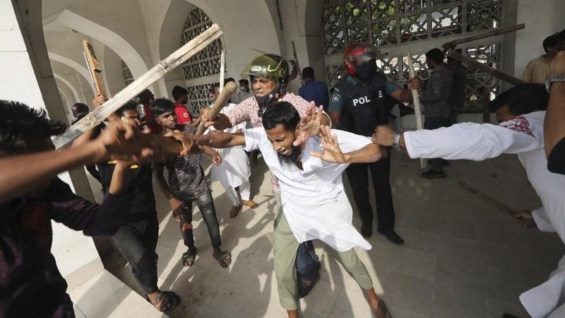 A group of protestors pelt stones on another after Friday prayers at Baitul Mokarram mosque in Dhaka, Bangladesh, Friday, March 26, 2021. Witnesses said violent clashes broke out after one faction of protesters began waving their shoes as a sign of disrespect to Indian Prime Minister Narendra Modi, and another group tried to stop them. Local media said the protesters who tried to stop the shoe-waving are aligned with the ruling Awami League party. The party criticized the other protest faction for attempting to create chaos in the country during Modi’s visit. (AP Photo/Mahmud Hossain Opu)