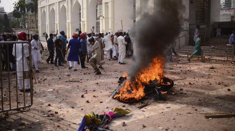 A group of protestors pelt stones on another after Friday prayers at Baitul Mokarram mosque in Dhaka, Bangladesh, Friday, March 26, 2021. Witnesses said violent clashes broke out after one faction of protesters began waving their shoes as a sign of disrespect to Indian Prime Minister Narendra Modi, and another group tried to stop them. Local media said the protesters who tried to stop the shoe-waving are aligned with the ruling Awami League party. The party criticized the other protest faction for attempting to create chaos in the country during Modi’s visit. (AP Photo/Mahmud Hossain Opu)