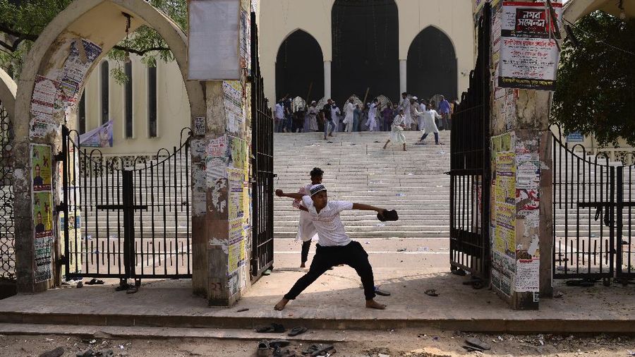 A group of protestors pelt stones on another after Friday prayers at Baitul Mokarram mosque in Dhaka, Bangladesh, Friday, March 26, 2021. Witnesses said violent clashes broke out after one faction of protesters began waving their shoes as a sign of disrespect to Indian Prime Minister Narendra Modi, and another group tried to stop them. Local media said the protesters who tried to stop the shoe-waving are aligned with the ruling Awami League party. The party criticized the other protest faction for attempting to create chaos in the country during Modi’s visit. (AP Photo/Mahmud Hossain Opu)