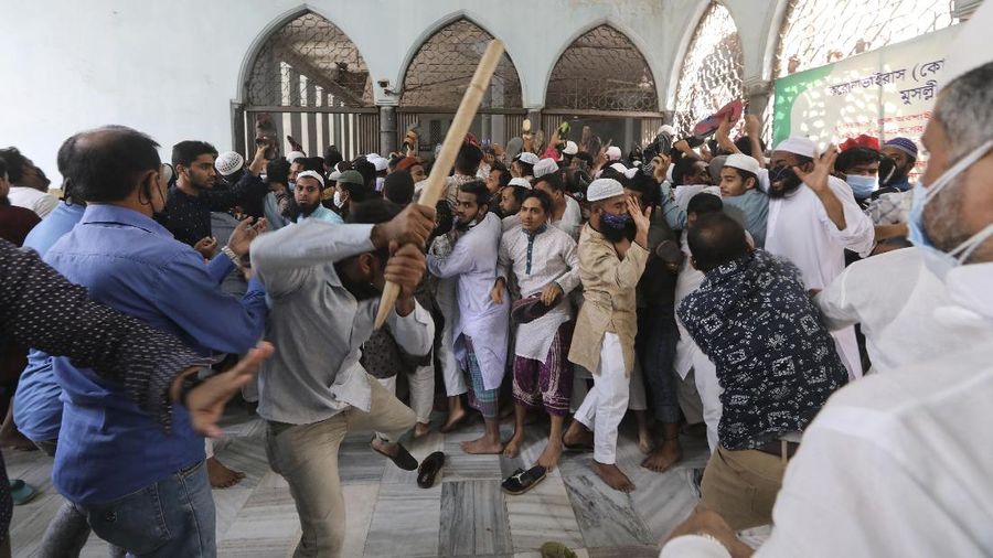 A group of protestors pelt stones on another after Friday prayers at Baitul Mokarram mosque in Dhaka, Bangladesh, Friday, March 26, 2021. Witnesses said violent clashes broke out after one faction of protesters began waving their shoes as a sign of disrespect to Indian Prime Minister Narendra Modi, and another group tried to stop them. Local media said the protesters who tried to stop the shoe-waving are aligned with the ruling Awami League party. The party criticized the other protest faction for attempting to create chaos in the country during Modi’s visit. (AP Photo/Mahmud Hossain Opu)