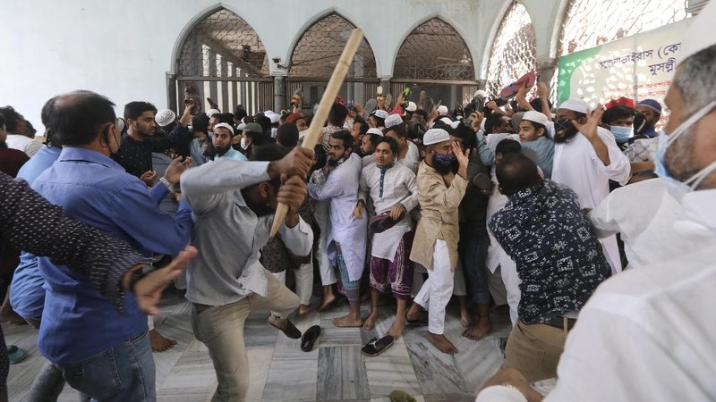 A group of protestors pelt stones on another after Friday prayers at Baitul Mokarram mosque in Dhaka, Bangladesh, Friday, March 26, 2021. Witnesses said violent clashes broke out after one faction of protesters began waving their shoes as a sign of disrespect to Indian Prime Minister Narendra Modi, and another group tried to stop them. Local media said the protesters who tried to stop the shoe-waving are aligned with the ruling Awami League party. The party criticized the other protest faction for attempting to create chaos in the country during Modi’s visit. (AP Photo/Mahmud Hossain Opu)