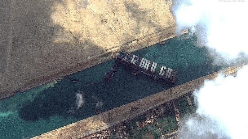 This satellite image from Maxar Technologies shows the cargo ship MV Ever Given stuck in the Suez Canal near Suez, Egypt, Friday, March 26, 2021. A maritime traffic jam grew to more than 200 vessels Friday outside the Suez Canal and some vessels began changing course as dredgers worked frantically to free a giant container ship that is stuck sideways in the waterway and disrupting global shipping. (©Maxar Technologies via AP)